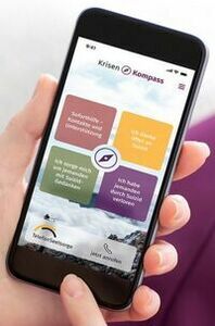 Eine Person hält ein Smartphone in der Hand. Auf dem Bildschirm sieht man die Krisen-App der Telefonseelsorge.